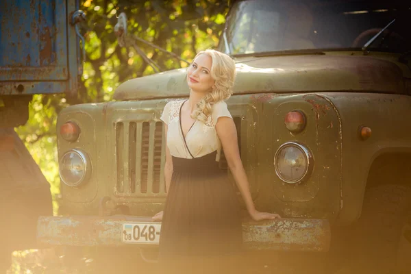 Schöne Frau posiert in der Nähe eines alten Lastwagens — Stockfoto