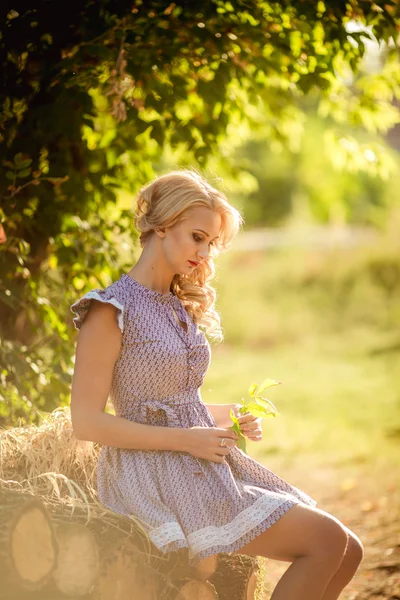 Blond kvinna i vårträdgård — Stockfoto