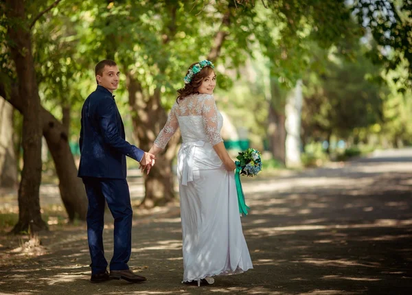 Bride with umbrella in the garden — Stock Photo, Image