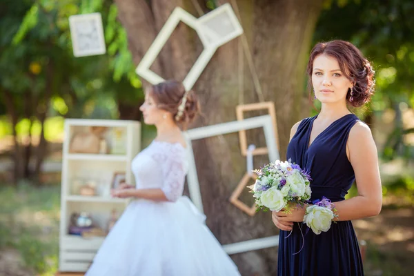 Bela noiva com dama de honra no jardim — Fotografia de Stock