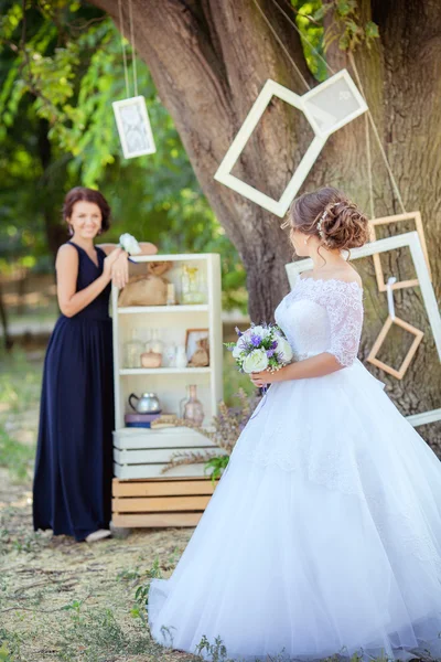 Bela noiva com dama de honra no jardim — Fotografia de Stock