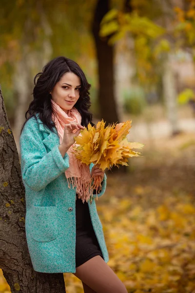 Girl with maple leaves in autumn garden — Stock Photo, Image