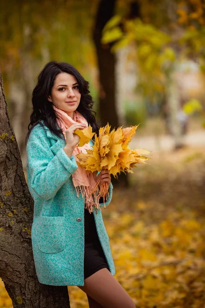 Girl with maple leaves in autumn garden — Stock Photo, Image