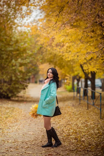 Дівчина з кленовим листям в осінньому саду — стокове фото