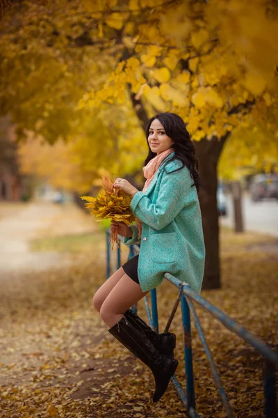 Menina com folhas de bordo no jardim de outono — Fotografia de Stock