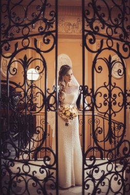 Bride posing behind forged door clipart