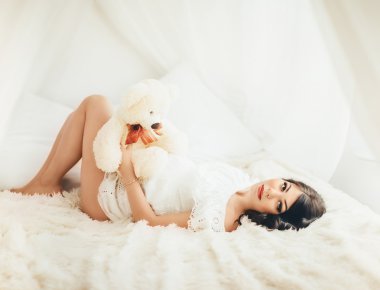 oyuncak ayı yatakta hamile kadınla