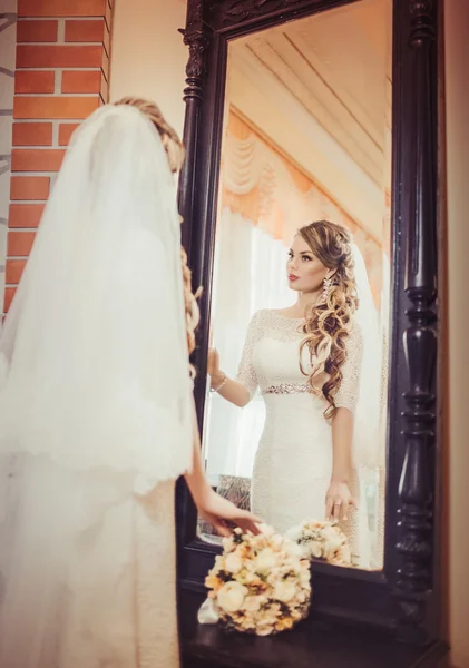 Krásná nevěsta při pohledu do zrcadla — Stock fotografie