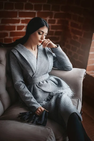 Жінка в модному одязі, сидячи на дивані — стокове фото