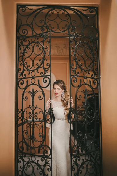 Menyasszony jelentő kovácsoltvas ajtó közelében — Stock Fotó