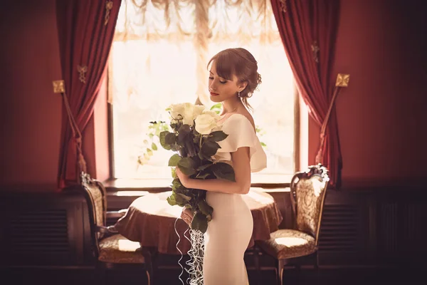 Schöne Braut mit Rosenstrauß — Stockfoto