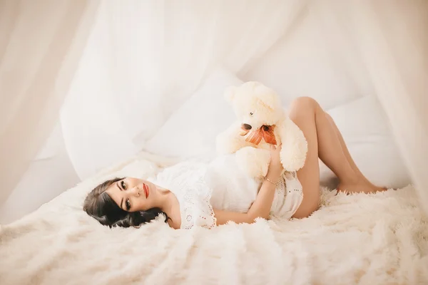 임신한 여자와 침대에 장난감 곰 — 스톡 사진