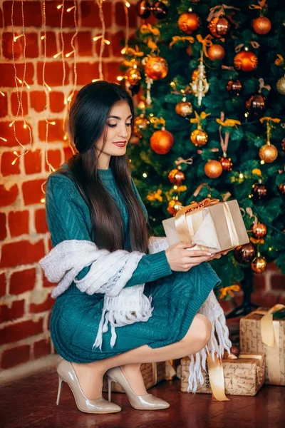 Woman with gift near Christmas tree — Stock Photo, Image