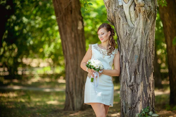 Nevěsta v bílých šatech v zahradě — Stock fotografie