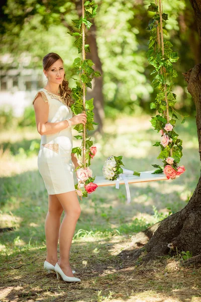 Bruden i vit klänning i trädgården — Stockfoto