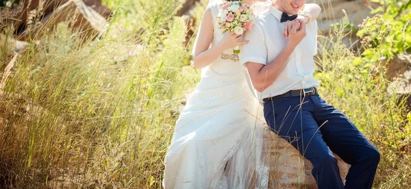 Novia y novio sentados en la piedra —  Fotos de Stock