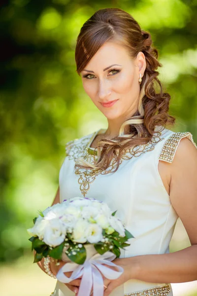 Nevěsta v bílých šatech v zahradě — Stock fotografie