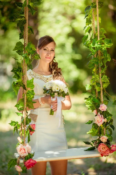 Bruid in witte jurk in de tuin — Stockfoto