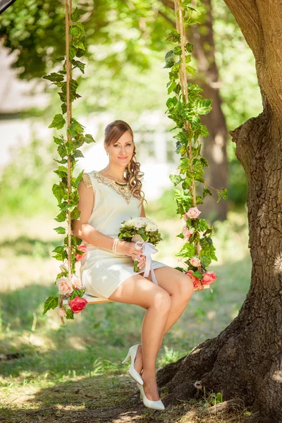 Bruid in witte jurk in de tuin — Stockfoto