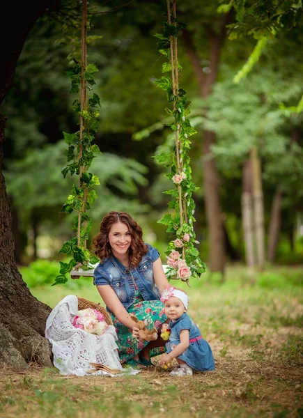 Mamma med barn flicka i vårträdgård — Stockfoto