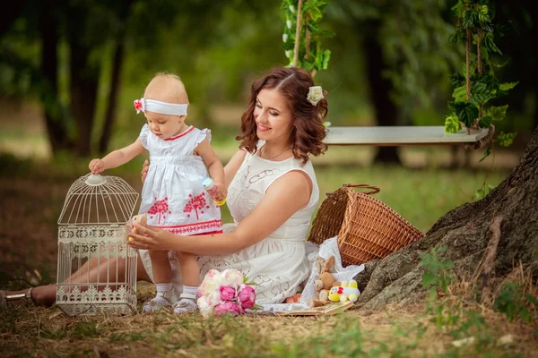 Mamma med barn flicka i vårträdgård — Stockfoto