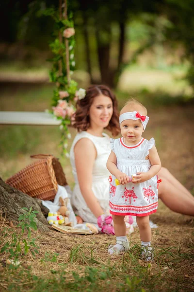 Mamma med barn flicka i vårträdgård — Stockfoto