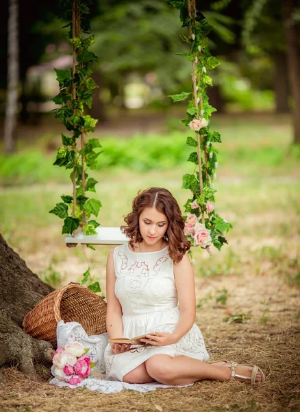 Mulher com livro de flores no jardim — Fotografia de Stock