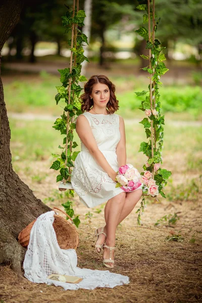 Vrouw met boeket van bloemen in de tuin — Stockfoto