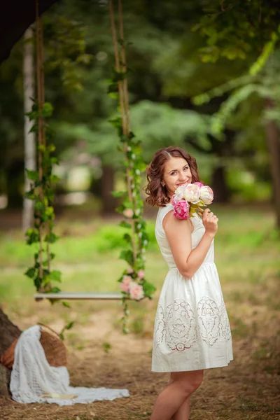 Frau mit Blumenstrauß im Garten — Stockfoto