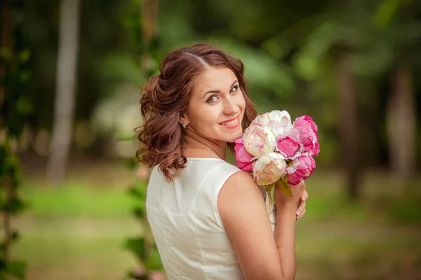 Mujer con ramo de flores en el jardín — Foto de Stock