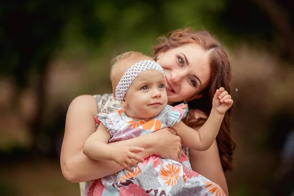 Moeder met babymeisje op lentetuin — Stockfoto