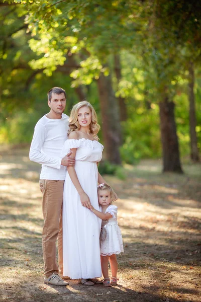 Belle famille de trois personnes dans jardin verdoyant — Photo