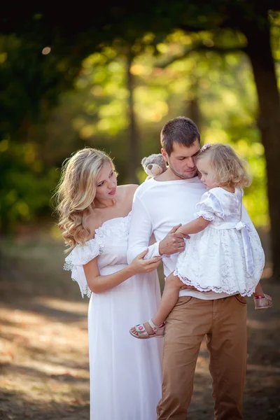 Belle famille de trois personnes dans jardin verdoyant — Photo