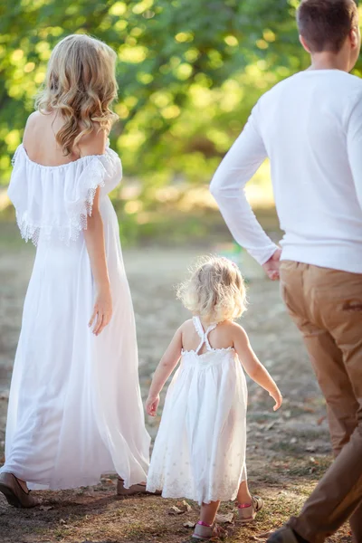 Bella famiglia di tre persone nel giardino verde — Foto Stock