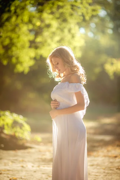 Красивая беременная женщина в парке — стоковое фото