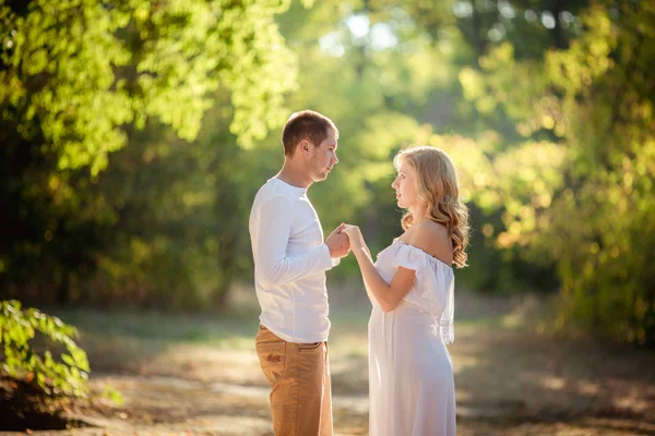 Gravid kvinna med sin man i trädgården — Stockfoto