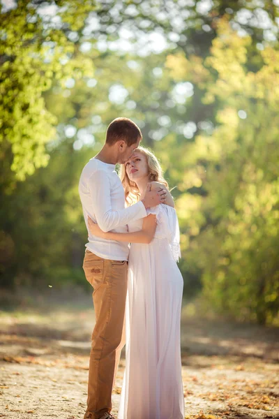 Zwangere vrouw met haar echtgenoot in de tuin — Stockfoto