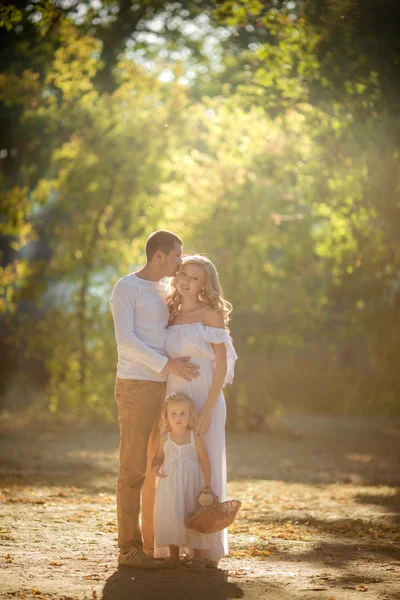 Família bonita de três no jardim verde — Fotografia de Stock