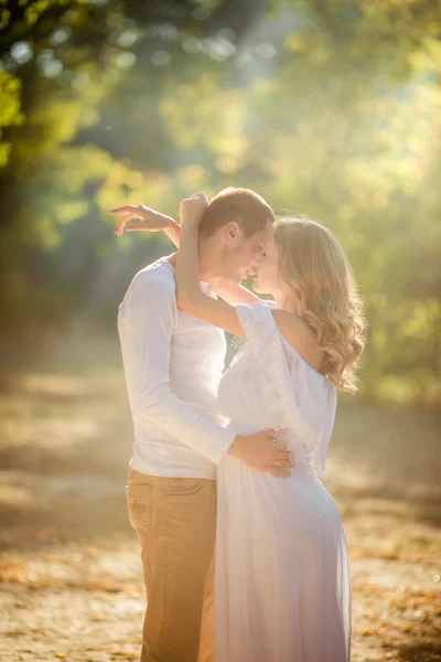 Pregnant woman with her husband in garden — Stock Photo, Image