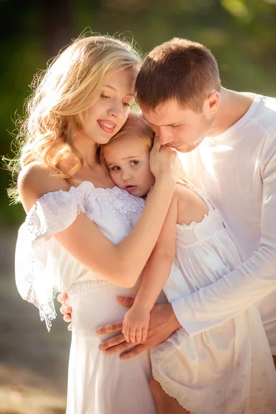 Belle famille de trois personnes dans jardin verdoyant — Photo