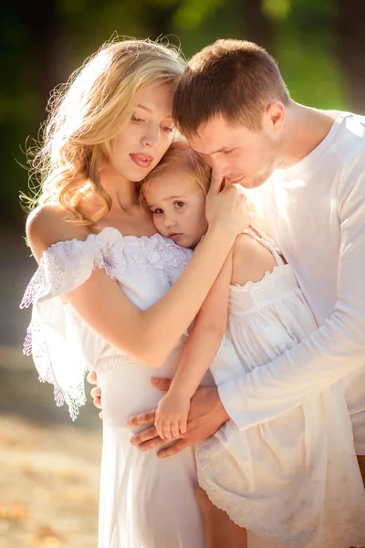 Belle famille de trois personnes dans jardin verdoyant — Photo