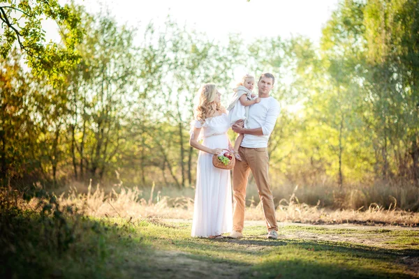 Vackra familj på tre i grönskande trädgård — Stockfoto