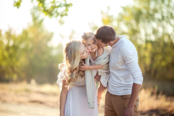 Belle famille de trois personnes dans jardin verdoyant — Photo