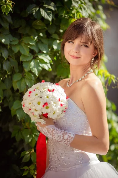 Schöne Braut mit Blumenstrauß — Stockfoto