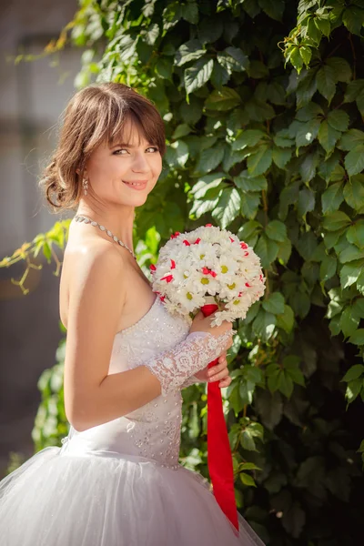 Schöne Braut mit Blumenstrauß — Stockfoto