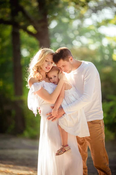 Beautiful family of three in green garden Stock Picture