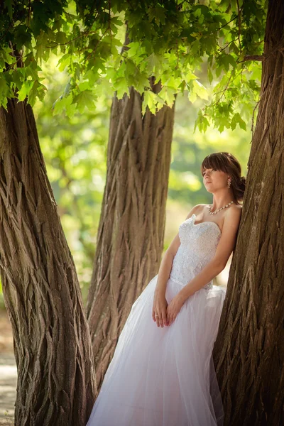 Bella sposa nel parco verde — Foto Stock
