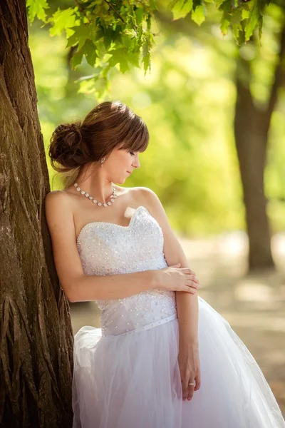 Beautiful bride in green park — Stock Photo, Image