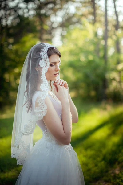 Bruden i vit klänning i trädgården — Stockfoto