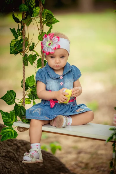 Hermosa niña sentada en columpio — Foto de Stock